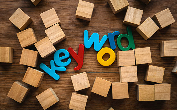 Letras talladas en madera forman la palabra "keywords", tema relacionado con las analisis de la competencia.