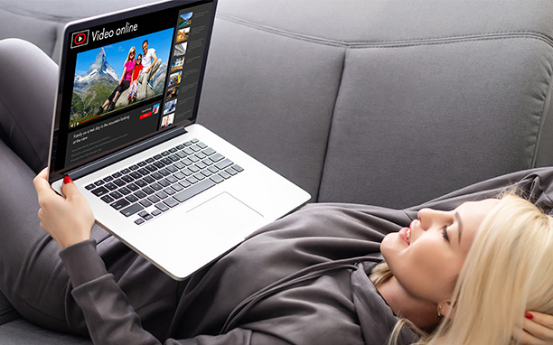 Illustrative art shows a woman lying on the sofa watching videos, referring to youtube adsense