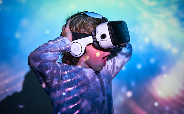 Garoto vestindo óculos de realidade virtual que é uma das tendencias marketing digital 2021.