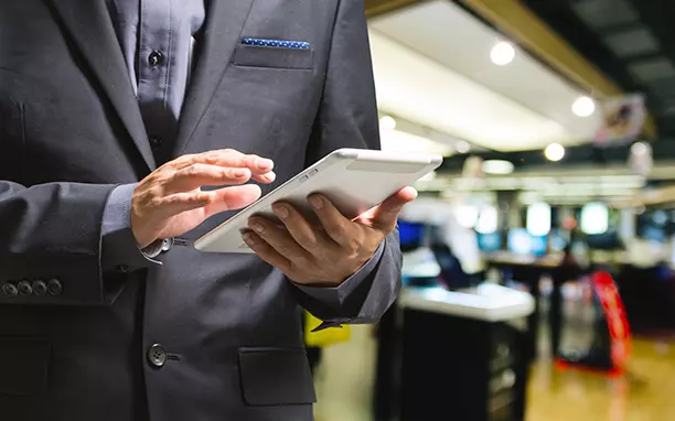 Homem utilizando tablet para pesquisar o que é trial